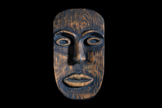 Ethnic tribal ritual handmade mask made from wood isolated on black background.