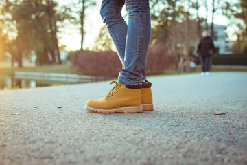 Girl in yellow boots standing on the sidewalk