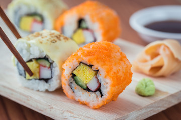 Sushi rolls on wooden plate