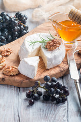 Brie cheese and a slice on  wooden board 