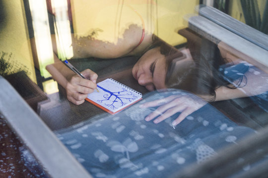 Brunette woman writing on a table
