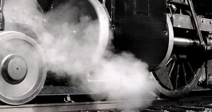 Close up of train wheels with steam