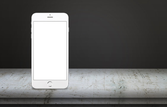White mobile phone on table. Vertical position with free space for text. Isolated mobile display for mockup. White table and dark, black background.