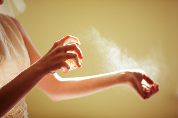 Woman sprays perfume over her delicate wirst