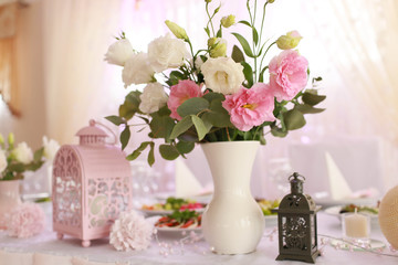 Obraz na płótnie Canvas Beautiful pink and delicate vase with flowers standing on the ta