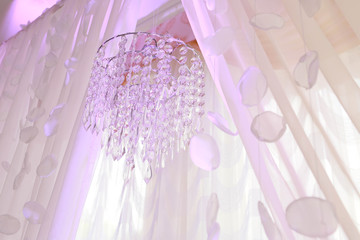 beautiful and charming crystal chandelier hangs in curtains
