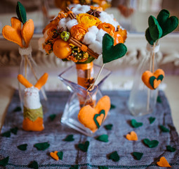 Orange and green paper hearts surround a glass vase with wedding
