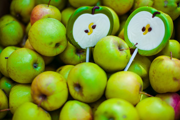 Green caramel sweets lie on the green apples