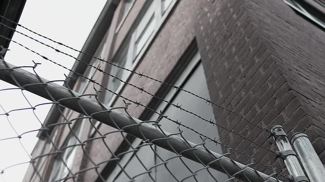 Low angle of barbwire fence and brick building