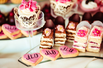 Fototapeta na wymiar Baked hearts with pink glaze lie behind the cakes