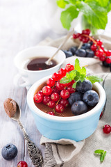 Delicious chocolate dessert with berries and mint served in ramekin.