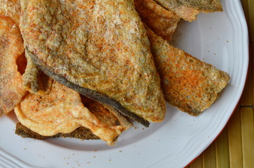 crispy fried fish skin with seasoning on dish