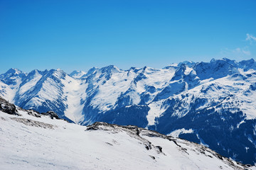 Fototapeta na wymiar Snowy slopes in winter mountains. Skiing resorts