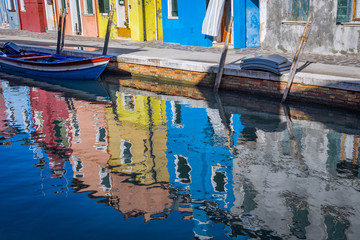 Fototapeta na wymiar Reflections of colorful houses in canal, Island of Burano, Italy