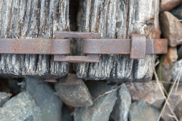 metal bracket with a buckle on the old railway sleepers. different textures close