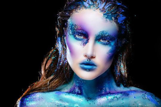 Portrait of a beautiful mermaid girl. Wet skin, wet hair, glitter and scales on his face. Blue eyes. The image on Halloween. Advertising Space.