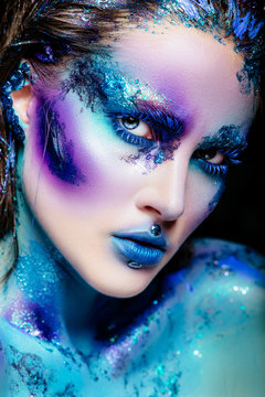 Portrait of a beautiful mermaid girl. Wet skin, wet hair, glitter and scales on his face. Blue eyes. The image on Halloween. Advertising Space.
