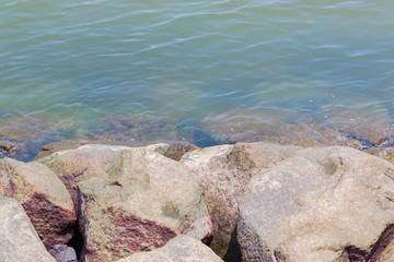 Large natural boulders  on blue water.