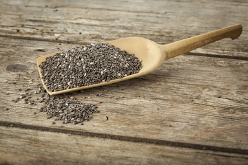 Chia seeds on wooden shovel, on rustic table