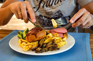 man eating his breakfast with fork and knife