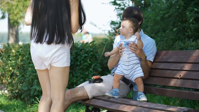 Mother looks at her child and then stroked his hand.