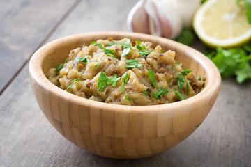 Baba ganoush and ingredients on wooden table

