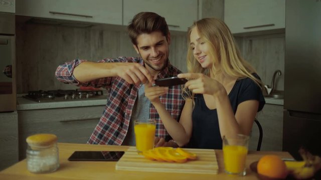 Couple making pictures of oranges.