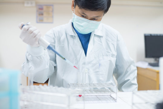 Asia scientis working in laboratory.using autopipett in work.