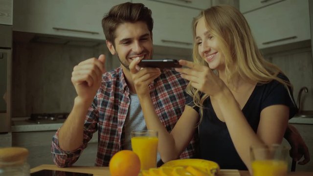 Couple photographing jus and oranges.
