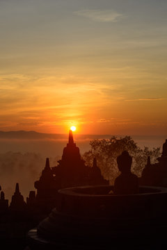 Buddha-Statue blickt in den Sonnenaufgang über Borobudur