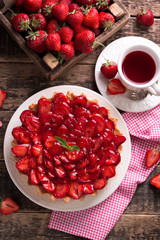 Tart with strawberries and whipped cream on wooden background