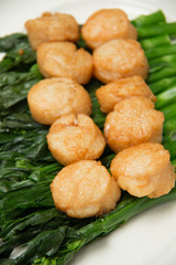  scallops and vegetables on white dish