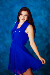 Brunette smiles broad while whirling her blue dress
