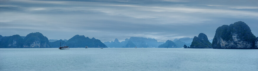 Early morning landscape with blue fog and tourist junks floating among limestone rocks at Ha Long Bay, South China Sea, Vietnam, Southeast Asia. Travel background, four images panorama