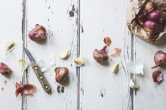 Shallots and garlic, with knife on white wood