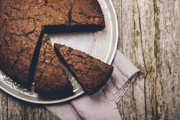 Healthy chocolate cake with beet on a gray plate with the effect of craquelure on the old wooden background. Selective focus. Toned