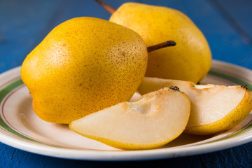 Fresh ripe organic yello pears on blue rustic wooden table, natural background, diet food.