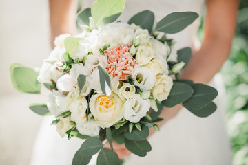 Closeup of white rose bouquet with large green leaves