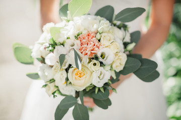 Bouquet of white roses decorated with pastel green leaves