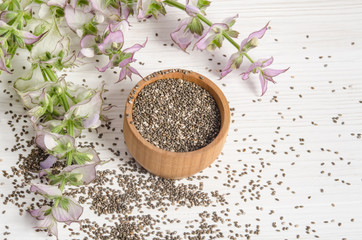 Chia seed healthy super food with flower over white wood backgro