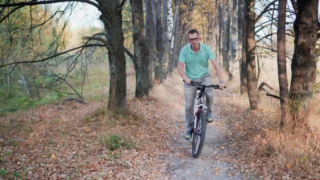 Man cyclist to riding a bicycle in the autumn forest