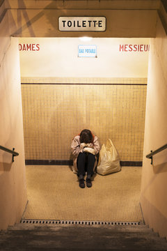 Femme sans-abri dormant dans des toilettes publiques