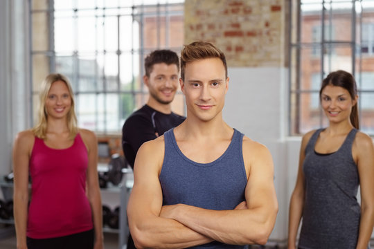 muskulöser mann im fitnessstudio mit team im hintergrund