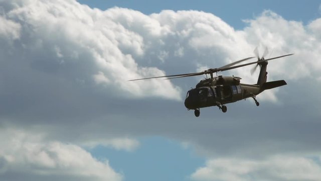 Slow motion of military helicopter flying in sky