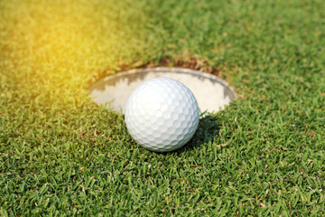 golf ball near the hole on green grass