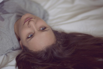 Close up portrait of beautiful sexy woman lying in bed. Relaxing and enjoying in her bedroom in the morning.