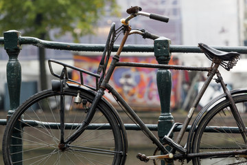 Fototapeta na wymiar Bicycle attached to bridge railing in Amsterdam