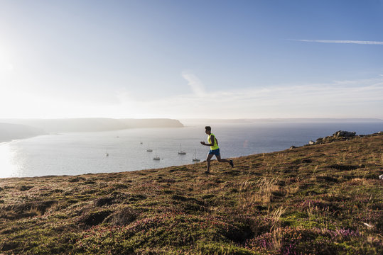 France, Crozon peninsula, young man running at the coast