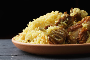 Rice pilaf with lamb in darkness closeup