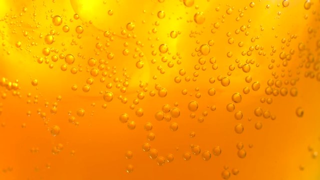 Close up of gold carbonated beverage bubbles